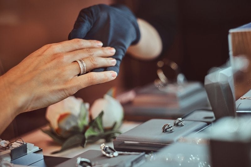 žena si skúša diamantový prsteň v luxusnom klenotníctve