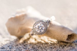 zásnubný prsteň z bieleho zlata v štýle pave vedľa morskej mušle