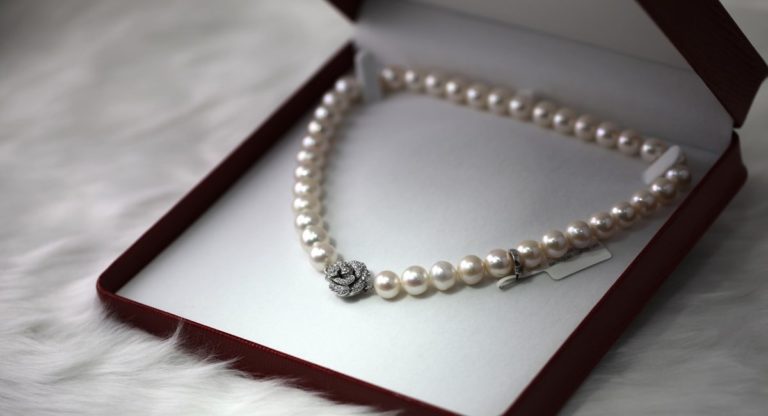 perlový náhrdelník uložený v mäkkej krabičke na bielom pozadí