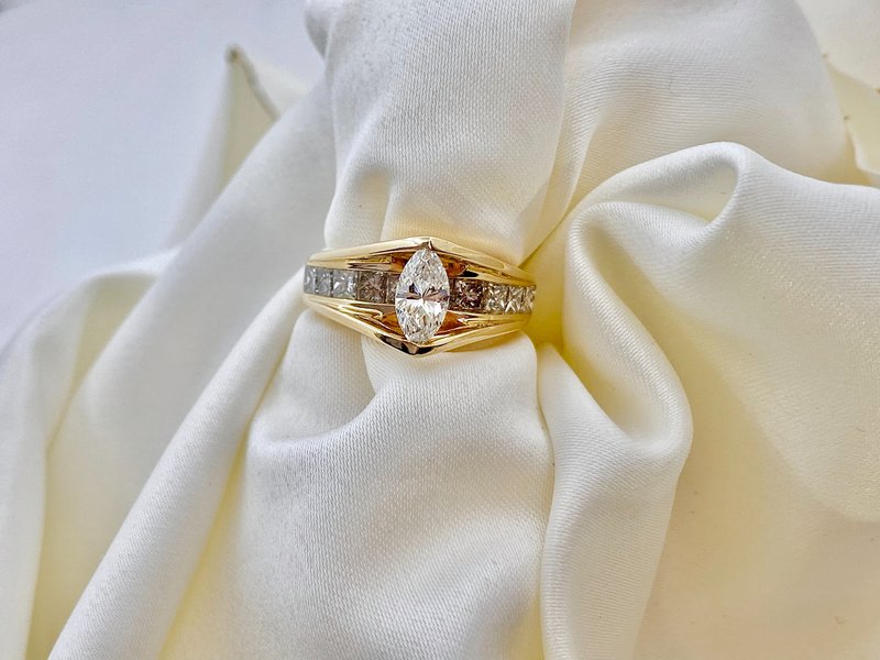 diamantový zásnubný prsteň zo žltého zlata prevlečený cez bielu látku