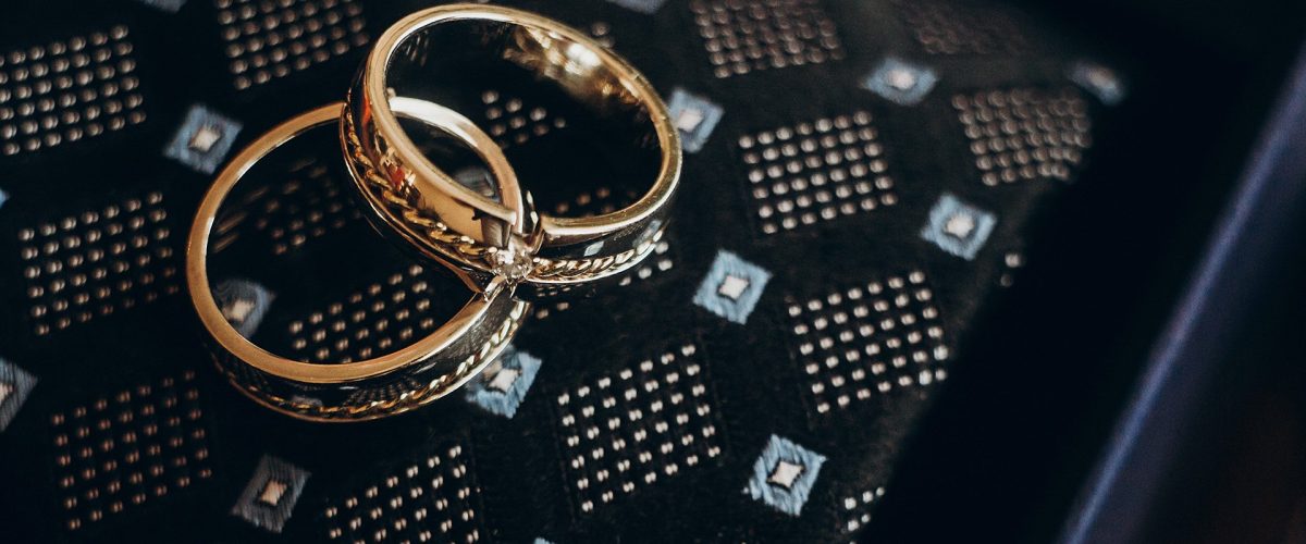 zlaté svadobné obrúčky s diamantmi na tmavom podklade